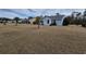 Landscaped backyard with a charming light blue home, palm trees, and well-manicured lawn at 1261 Pineridge St., Conway, SC 29527