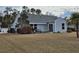 Spacious backyard with patio set under a blue awning and view of light blue house at 1261 Pineridge St., Conway, SC 29527