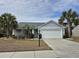 Charming single-story home with a two-car garage, well-manicured lawn, and mature palm trees at 1261 Pineridge St., Conway, SC 29527