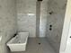 Elegant bathroom with a freestanding tub, walk-in shower, and sleek marble-style tiling at 135 Low Country Loop, Murrells Inlet, SC 29576