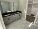 Modern bathroom featuring dual sinks, granite countertops, marble flooring, and a luxurious bathtub at 135 Low Country Loop, Murrells Inlet, SC 29576