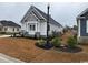 Side view of a beautifully landscaped home with a manicured lawn and charming architectural details at 135 Low Country Loop, Murrells Inlet, SC 29576