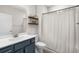 Bathroom featuring a dark blue vanity, floating wood shelves, and a shower with white curtain at 136 Starlit Way, Myrtle Beach, SC 29579