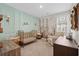 Cozy Bedroom with a gold crib, decorative paneling, and a mountain-themed mural at 136 Starlit Way, Myrtle Beach, SC 29579