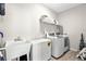 Functional laundry room with modern washer and dryer, utility sink, and storage shelving at 136 Starlit Way, Myrtle Beach, SC 29579