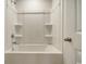 Clean, well-lit bathroom shower and tub combination featuring molded shelving at 1369 Palm Springs Paloma Dr, Longs, SC 29568