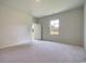 Large bedroom with new carpet, a window, and an open doorway to the hallway at 1369 Palm Springs Paloma Dr, Longs, SC 29568