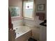 Bright bathroom with a soaking tub, white tile, and natural light from the window at 1372 Oakmont Ct., Murrells Inlet, SC 29576