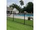 Community pool with clear blue water, metal fencing, lounge chairs, and trees in the background at 1372 Oakmont Ct., Murrells Inlet, SC 29576