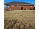 Brick house with a large, grassy backyard and minimal landscaping at 1375 Kenny Jordan Rd, Tabor City, NC 28463