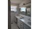 Tiled bathroom featuring double sinks and a glass-enclosed shower, offering a bright and functional space at 1375 Kenny Jordan Rd, Tabor City, NC 28463