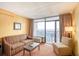 Cozy living room featuring balcony access and partial ocean views at 1501 S Ocean Blvd. # 1131, Myrtle Beach, SC 29577