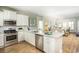 Modern kitchen equipped with stainless steel appliances, granite countertops, white cabinetry, and a seamless connection to living space at 1509 Seachase Way, North Myrtle Beach, SC 29582