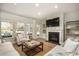 Well-lit living room offers hardwood floors, neutral furnishings, a modern fireplace, and views of the outdoor landscape at 1509 Seachase Way, North Myrtle Beach, SC 29582