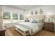 Serene main bedroom features a comfortable bed, bench, and a decorative mirror on the wall, with multiple windows at 1509 Seachase Way, North Myrtle Beach, SC 29582