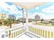View of the street and neighborhood from a covered balcony with white railings at 1614-B S Ocean Blvd., Surfside Beach, SC 29575