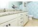 Bathroom featuring a double vanity with a granite countertop, white cabinetry, and a decorative shower curtain at 1614-B S Ocean Blvd., Surfside Beach, SC 29575