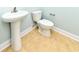 Half bathroom features a modern sink and toilet with tan tile flooring at 1614-B S Ocean Blvd., Surfside Beach, SC 29575