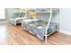 Bedroom with wood flooring featuring two bunk beds with white frames and patterned quilts at 1614-B S Ocean Blvd., Surfside Beach, SC 29575