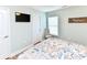 A well-lit bedroom features a flat-screen TV, a charming chair, and serene decor for relaxation at 1614-B S Ocean Blvd., Surfside Beach, SC 29575