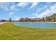 Beautiful pond surrounded by lush greenery, with a glimpse of the home in the distance at 1751 Nichols Hwy., Aynor, SC 29511
