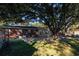 Large, fenced backyard featuring mature trees, a brick patio, and a cozy fire pit at 1916 Jasper St., Georgetown, SC 29440