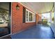 Cozy front porch featuring brick wall, swing, and large windows for ample natural light at 1916 Jasper St., Georgetown, SC 29440