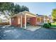 Side view of a brick ranch home with covered parking, and a cozy front porch at 1916 Jasper St., Georgetown, SC 29440