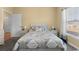 A cozy bedroom featuring a queen-sized bed with a patterned comforter and matching shams, bedside tables and large window at 195 Cupola Dr., Longs, SC 29568