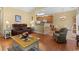 Inviting living room features hardwood floors, a cozy chair, and a view of the kitchen bar at 195 Cupola Dr., Longs, SC 29568