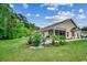 Large backyard featuring a well-maintained lawn, lush landscaping, and a screened porch at 196 Rose Water Loop, Myrtle Beach, SC 29588