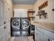 A functional laundry room includes gray front-load machines, storage cabinets, and ample counter space at 196 Rose Water Loop, Myrtle Beach, SC 29588