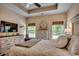 A comfortable main bedroom boasts natural light, tray ceiling and coordinated decor with a TV at 196 Rose Water Loop, Myrtle Beach, SC 29588