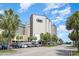 Beautiful resort exterior with palm trees, blue skies, and ocean views at 200 76Th Ave. N # 410, Myrtle Beach, SC 29572