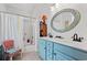 Bright bathroom featuring a double sink with blue vanity and oval mirror, plus a shower and decorative chair at 209B Woodland Dr., Murrells Inlet, SC 29576