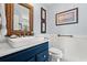 Stylish bathroom features a navy blue vanity with a white sink, rope mirror, and nautical-themed decor at 209B Woodland Dr., Murrells Inlet, SC 29576