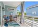 Relaxing porch features a table and chairs with blue cushions, a patterned rug, and neighborhood views at 209B Woodland Dr., Murrells Inlet, SC 29576