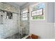 Modern shower boasts subway tile, a built-in shelf, and a window adding natural light to the space at 209B Woodland Dr., Murrells Inlet, SC 29576