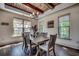 Sunlit dining room with rustic wood table, exposed wood ceiling beams, and views of the landscaped yard at 2131 Timmerman Rd., Myrtle Beach, SC 29588