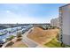 Scenic aerial view of a coastal area with marina, waterway, a multi-story building, and lush landscaping at 2151 Bridge View Ct. # 2705, North Myrtle Beach, SC 29582