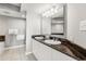 Bathroom with double vanity sink, granite counters, tile floor, and a large mirror with decorative lighting at 2151 Bridge View Ct. # 2705, North Myrtle Beach, SC 29582