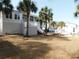 Backyard with palm trees, an outdoor patio, and a fenced area, showcasing outdoor living at 220 Starcrest Circle, North Myrtle Beach, SC 29582
