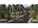 Scenic entrance to Crescent Cove with lush landscaping, palm trees, and a welcoming atmosphere at 232 River Edge Dr., Myrtle Beach, SC 29588