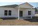 A backyard with a patio and two windows offers an inviting outdoor living and relaxing space at 242 Warner Crossing Way, Loris, SC 29569