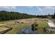 An aerial view of the community featuring plots, trees, a pond, playground, and paved road, showcasing the layout and green spaces at 262 Christiana Ln. # C, Myrtle Beach, SC 29579