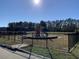 Fenced playground with slides, climbing equipment, and soft landing surface, providing a secure recreational area surrounded by trees at 262 Christiana Ln. # C, Myrtle Beach, SC 29579