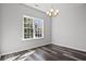 Dining room featuring wood-look flooring, large window, modern lighting fixture, and neutral paint at 272 Stillbrook Dr., Longs, SC 29568