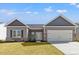 Charming single-story home featuring a well-manicured lawn, inviting entryway, and attached two-car garage at 272 Stillbrook Dr., Longs, SC 29568
