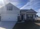 Charming two-story home with a two car garage, gray siding, and a well manicured lawn at 275 Stillbrook Dr., Longs, SC 29568