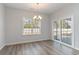 Light filled dining area featuring wood-look floors, modern chandelier, sliding door and a large window at 276 Stillbrook Dr., Longs, SC 29568